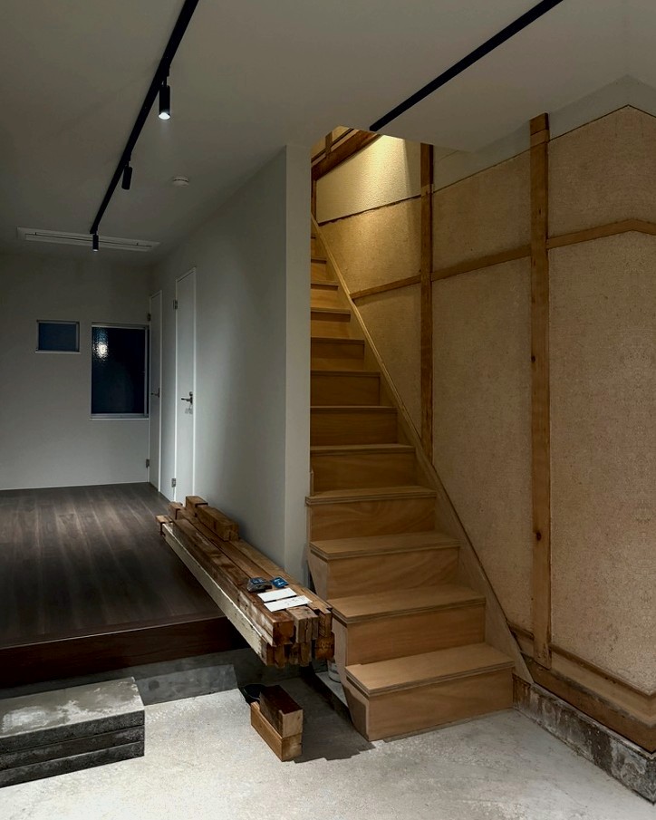 The ground-floor gallery space: a raised timber floor, track lighting and the original stair
