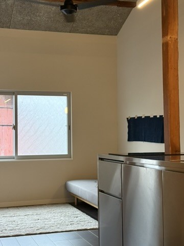 Upper Suite: living space under the original beams, with a daybed and kitchen counter