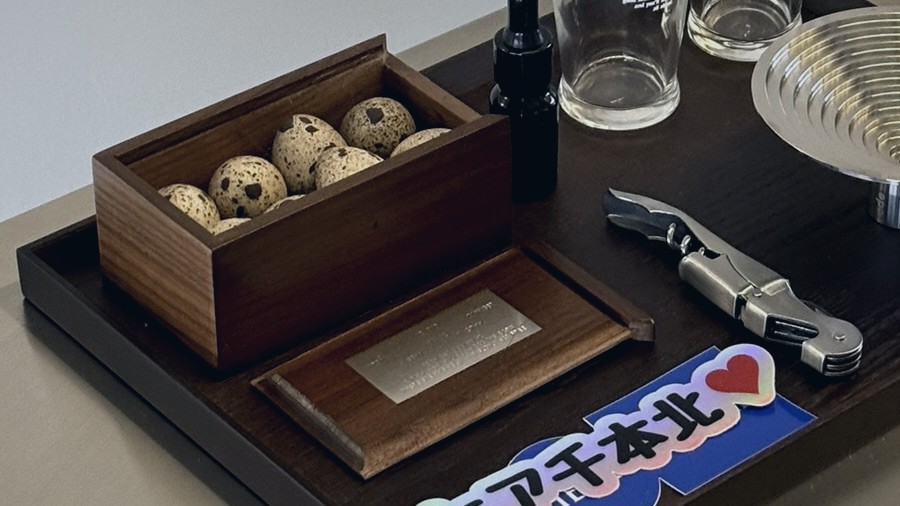 The welcome tray on the kitchen counter: Ode's speckled eggs in a walnut box, Kirin glasses, a steel diffuser and a HERE Senbonkita sticker